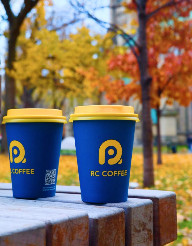 Two coffee cups on edge of a picnic table
